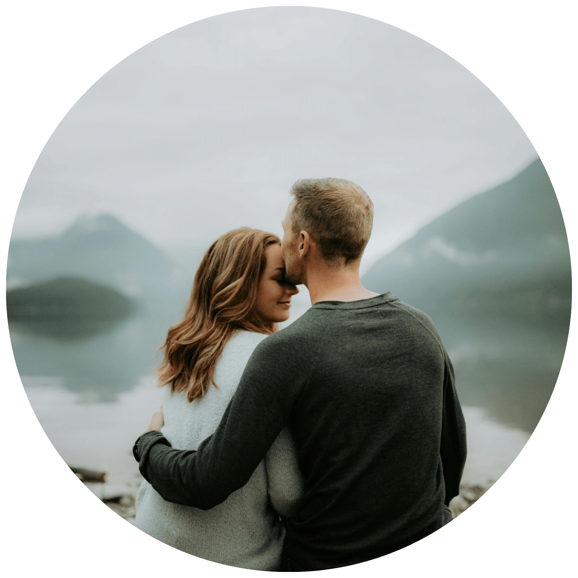 Couple holding each other in front of a lake