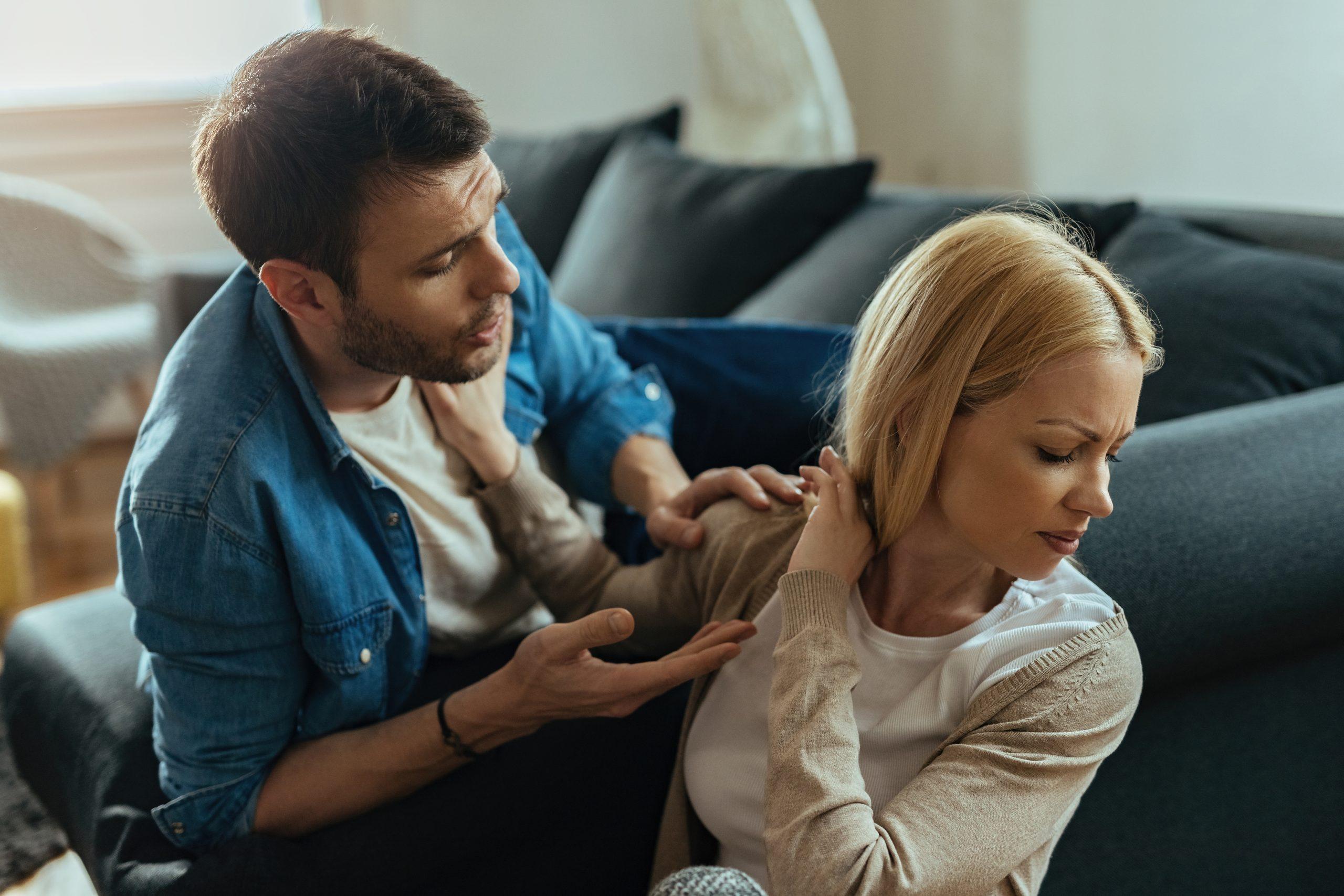 Displeased woman refusing to talking with her boyfriend while having an argument at home.